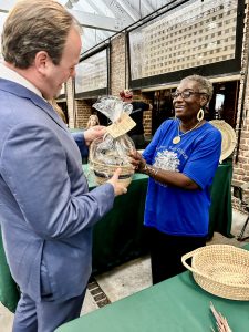 Charleston Mayor William Cogswell presents a Certified Local 100% Made in Charleston Award to vendors at the Charleston City Market